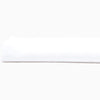 A John Robshaw Organic White Fitted Sheet, made of organic cotton, lying on top of a white surface in India.