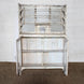 The Saahil Wooden Sideboard by John Robshaw, finished in a charming distressed whitewash, features open upper shelving, elegant glass-front storage panels, and lower cabinet doors that reveal spacious interior shelves—beautifully set against a crisp white wall.