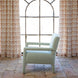Placed before a large arched window with patterned curtains and set on a tiled floor, the Square Chair in Aleppo Sage by John Robshaw features custom upholstery in durable performance fabric—an elegant seating choice that brings both comfort and style to your living space.