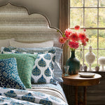 A bed with Bilva Peacock Organic Duvet bedding by John Robshaw and a vase of flowers. - 30784071991342