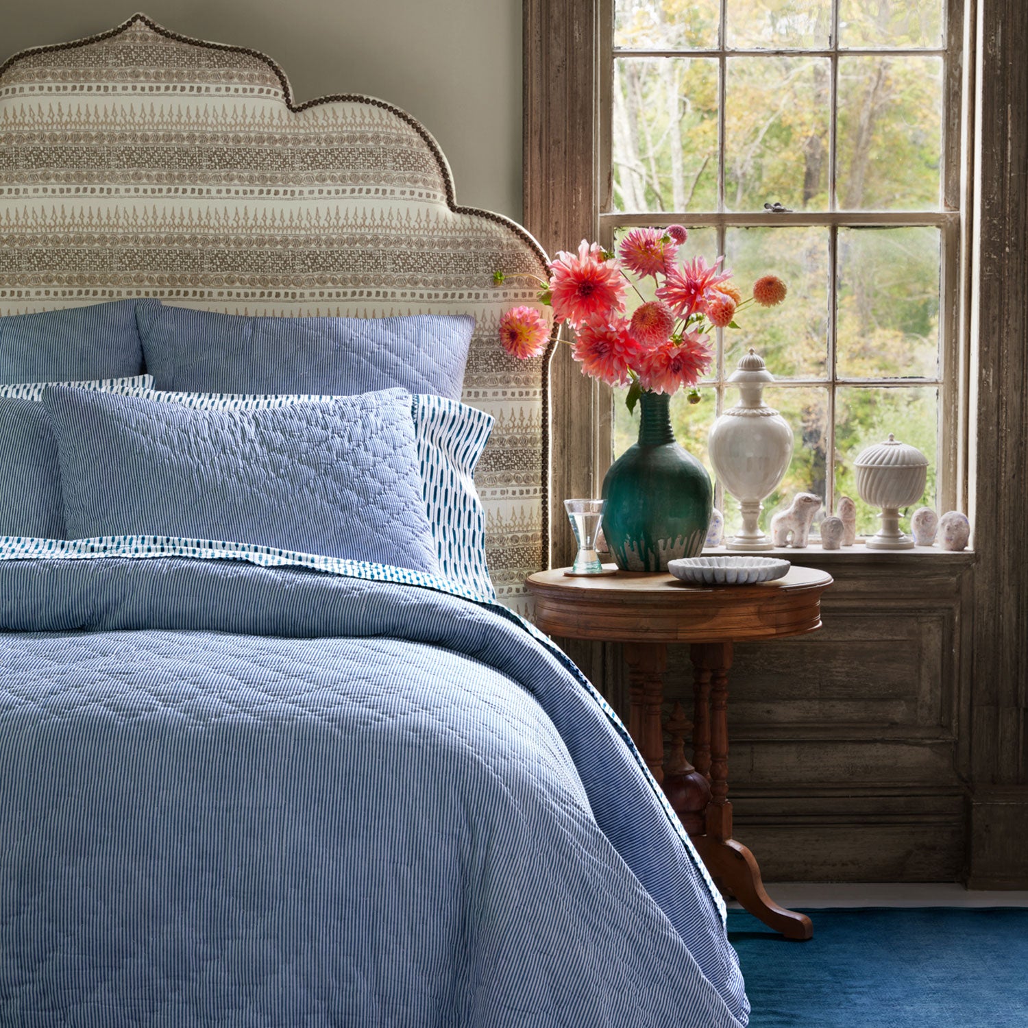 A blue and white bedroom with a Nandi Indigo Quilt bed featuring simple stripes by John Robshaw.
