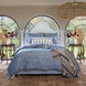 A Nandi Indigo Quilt bed in a bedroom with arched windows, featuring simple stripes. (Brand: John Robshaw)