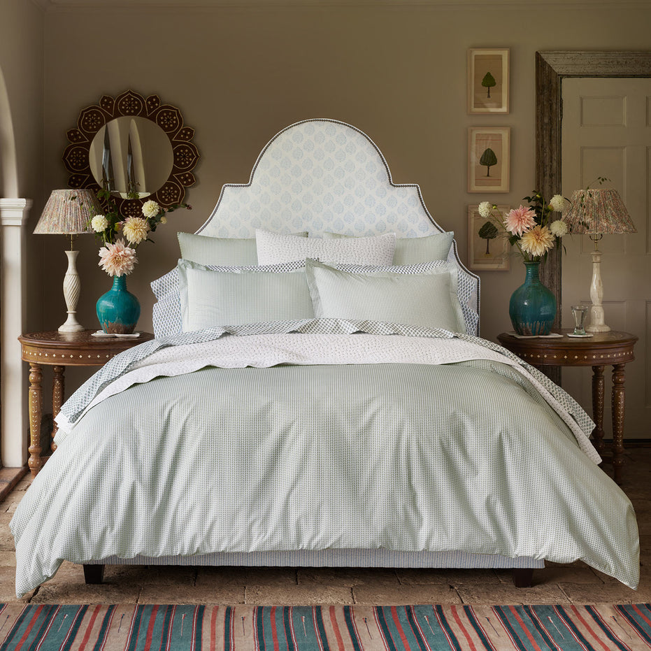 A bedroom with a Cinde Sage Organic Duvet made of organic long staple cotton, designed by John Robshaw.