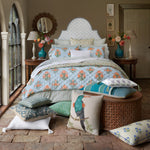 A soft woven John Robshaw Ivory Kidney Pillow on a bed. - 30801455022126
