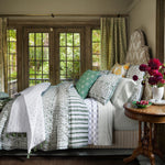 A bedroom with a green and white John Robshaw Lina Sage Quilt comforter and pillows made from cotton voile fabric. - 30783867682862