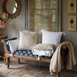 A blue and white cushioned bench with John Robshaw's Woven Ivory Decorative Pillow. - 30801466261550