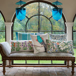 A bench with blue pillows, John Robshaw's Arav Decorative Pillow, and hand-painted blue lanterns in front of an arched window. - 30801467834414