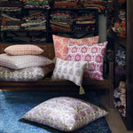 A room with a lot of John Robshaw Sofi Lavender Kidney Pillows on a blue rug. - 30801469702190