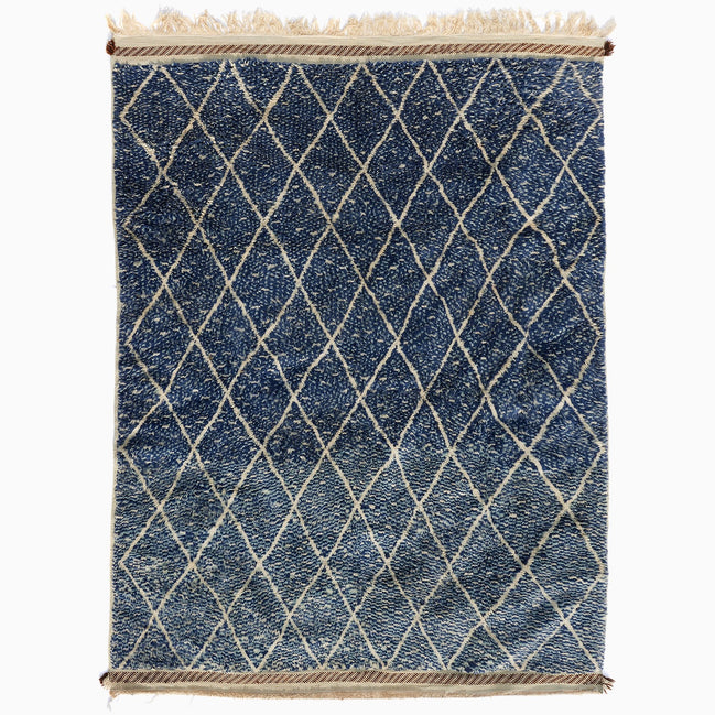 Blue Village 2 Wool Rug: a blue rectangular handwoven Moroccan rug with a white lattice design and fringed ends.