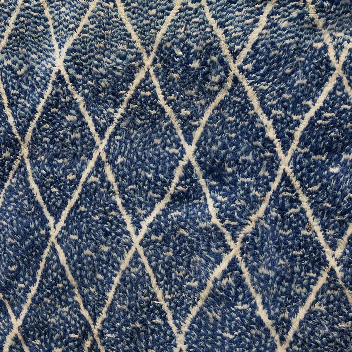 Blue Village 2 Wool Rug in blue with a textured surface and a white diamond lattice design.