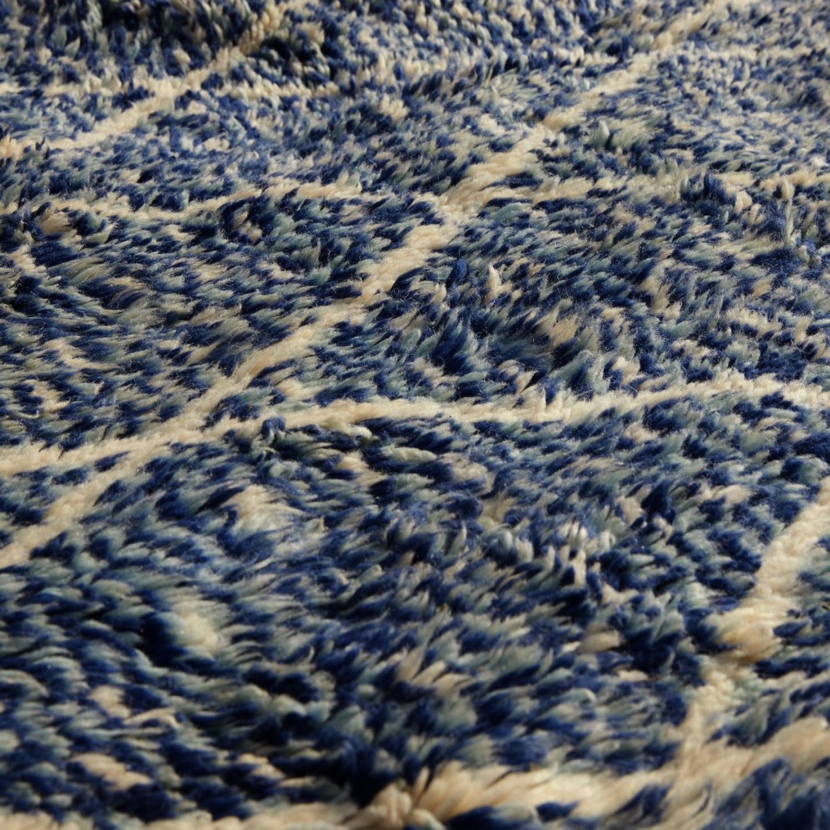 Close-up of the shaggy Blue Village 2 Wool Rug featuring a blue and white traditional lattice design.