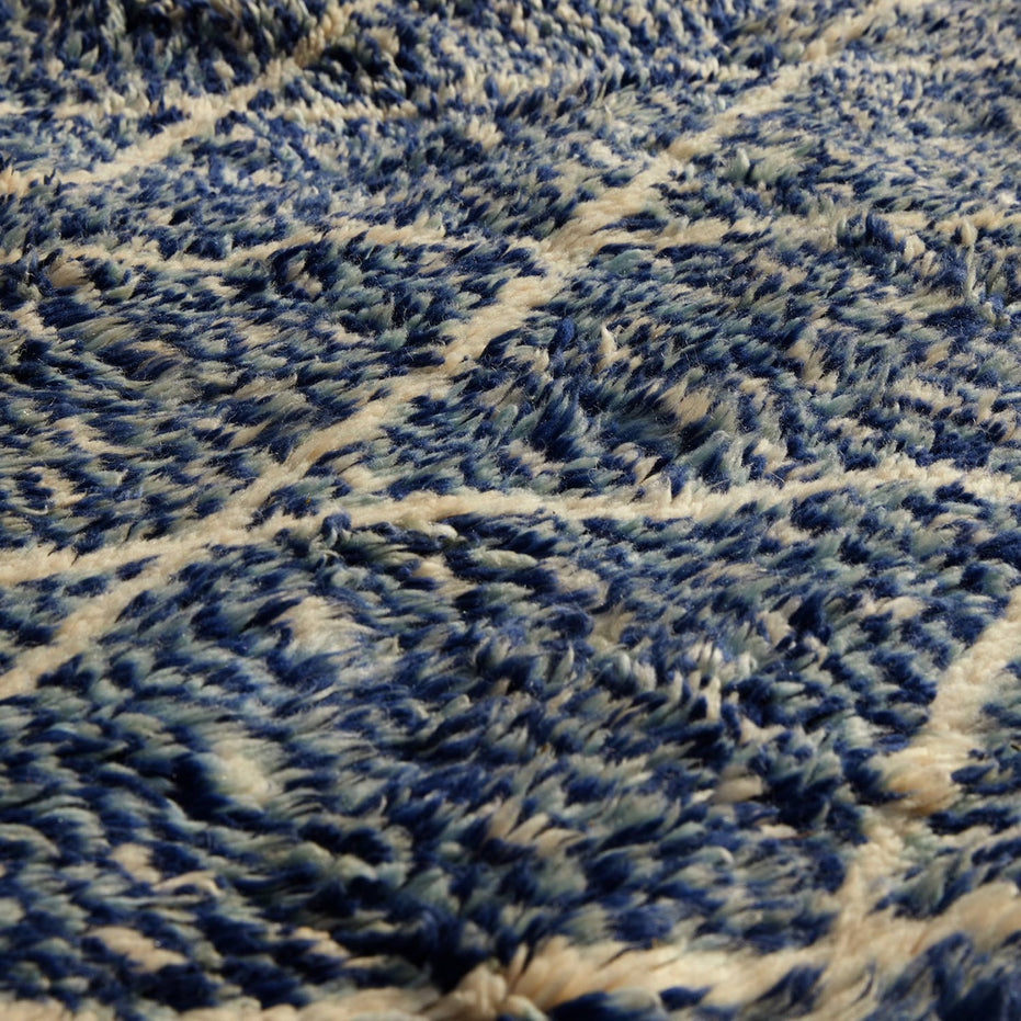 Close-up of the shaggy Blue Village 2 Wool Rug featuring a blue and white traditional lattice design.