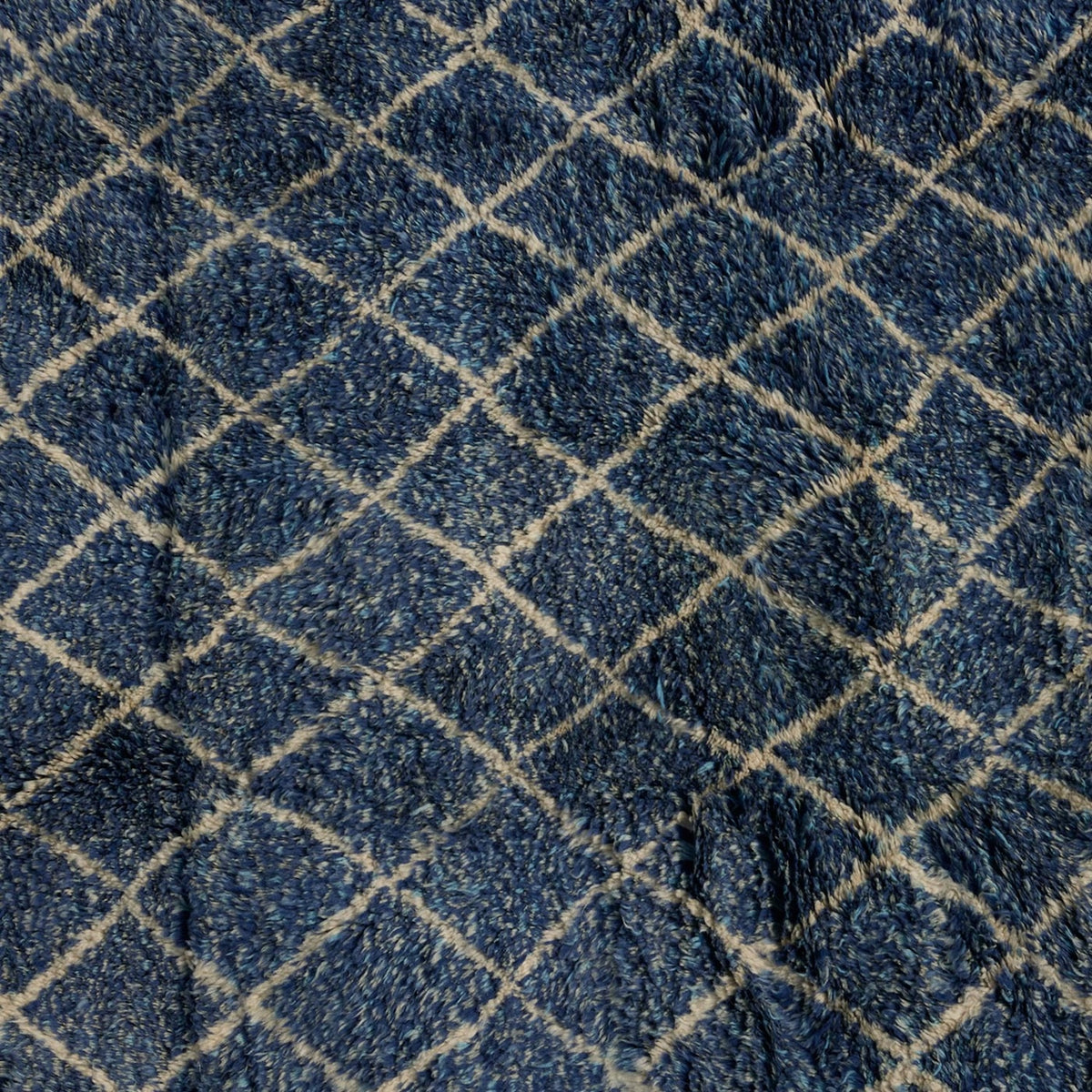 Dark blue handwoven Blue Village Wool Rug by John Robshaw with a white diamond grid pattern.
