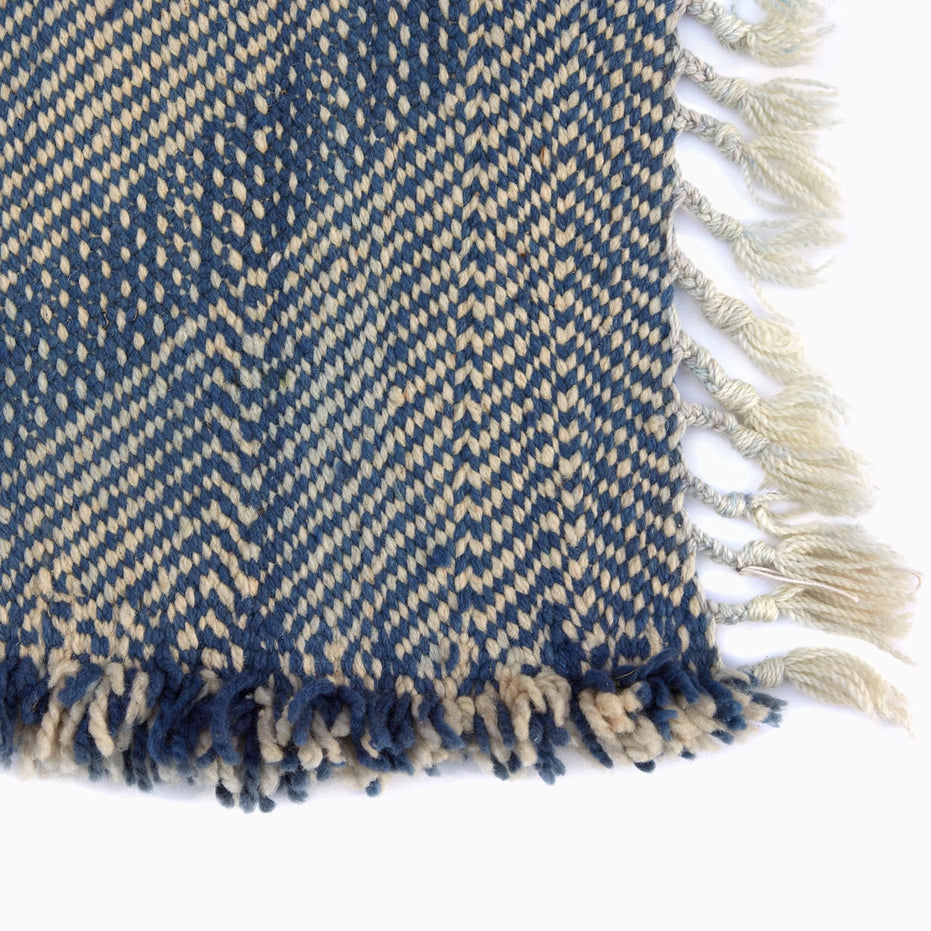 Big Zanafi Wool Rug featuring a blue and cream chevron pattern with fringed edges.