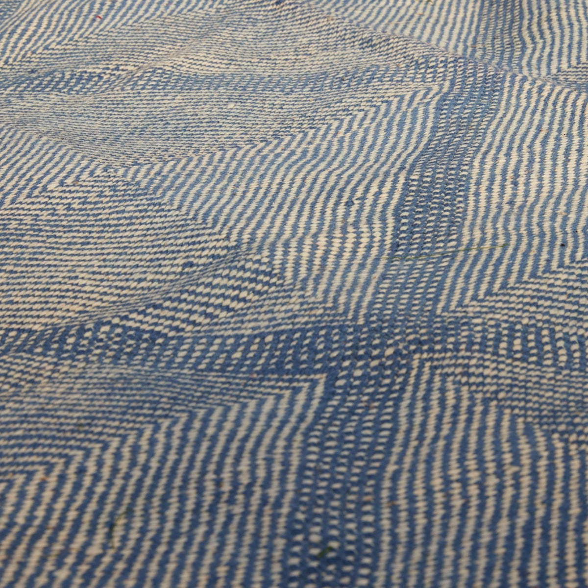 John Robshaw Big Zanafi Wool Rug in blue and white, featuring a handwoven geometric diamond pattern formed by textured stripes inspired by traditional Atlas mountains designs.