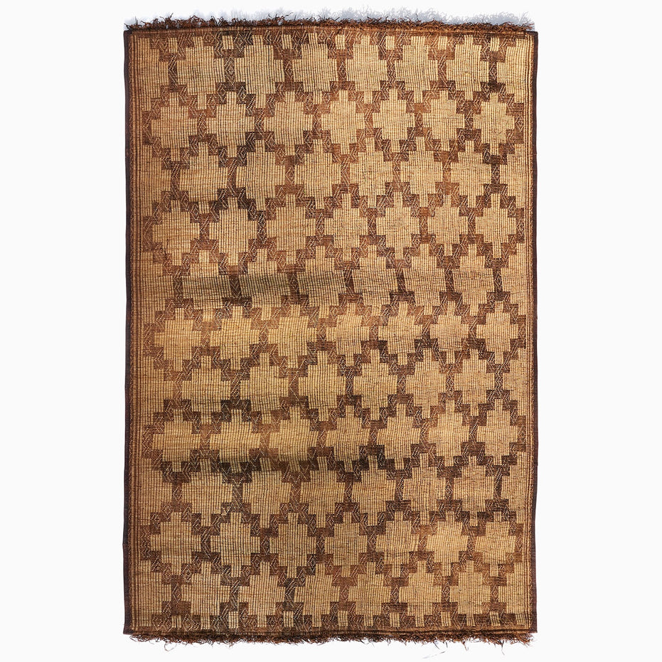 John Robshaw Tazarine Tuareg Mat with a handwoven, repeating brown geometric diamond pattern and fringed top and bottom edges.