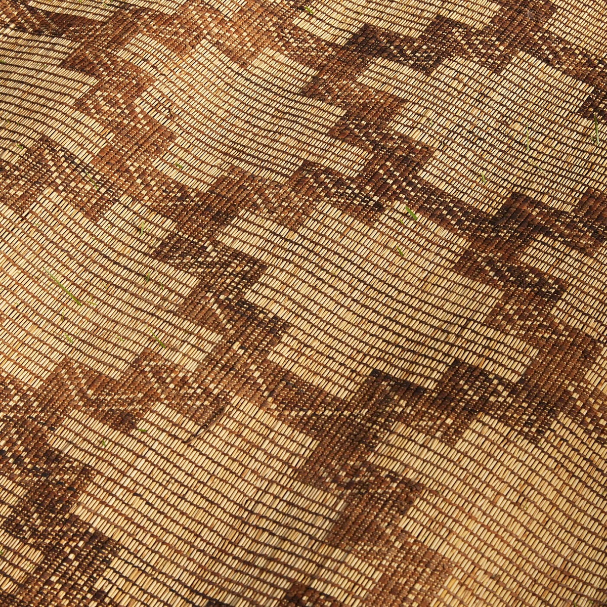 Handwoven Tazarine Tuareg mat by John Robshaw featuring a geometric pattern in shades of brown and tan.