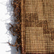 Close-up of a handwoven Tazarine Tuareg Mat with a dark brown leather border and a frayed, stringy edge.