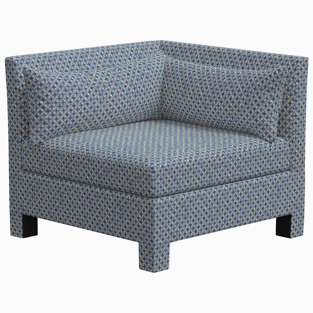 The John Robshaw Sameera Corner Chair features an exclusive polka dot pattern on its blue fabric, creating a custom seating arrangement.