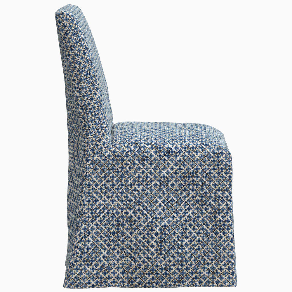 A John Robshaw Sadia Slipcover Chair, featuring a blue and white patterned slipcover, perfect for any dining room.