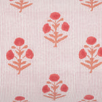 A close-up of the Lucy Coral Bolster from John Robshaw, a cotton linen pillow featuring a fabric pattern with red floral motifs and vertical pink stripes, hand block printed and made in India. - 31261339942958