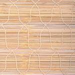 Close-up of woven bamboo mat showcasing intricate patterns like Lapis Chik Blinds by John Robshaw Textiles, featuring interlocking ovals formed by twisted white threads on a light, natural background. - 31884733579310