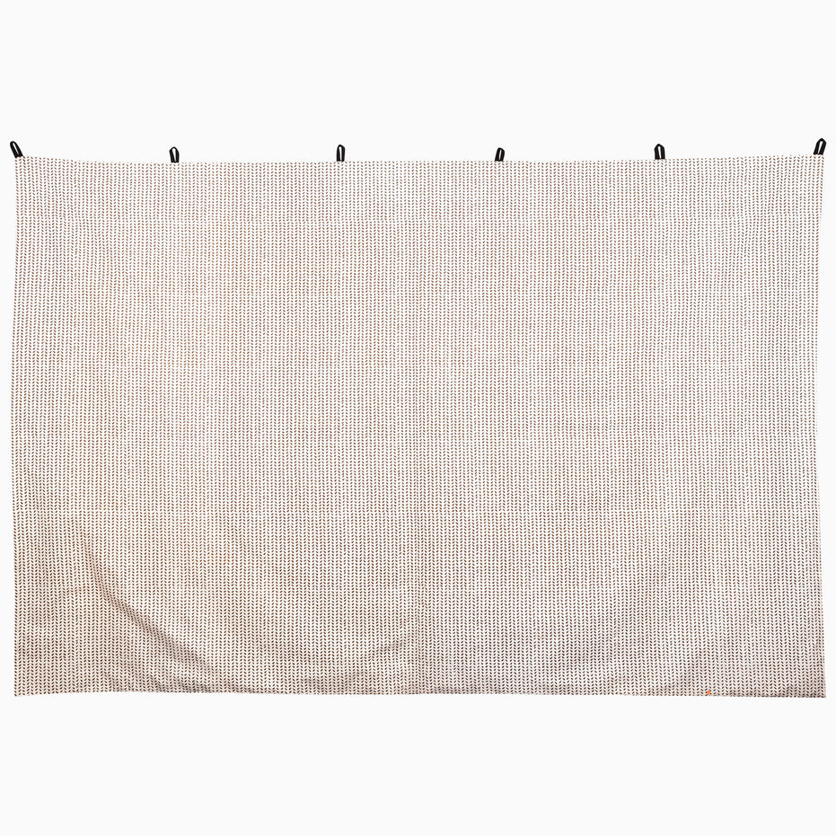 John Robshaw Trotting Camel Tapestry, a rectangular hand-painted piece with a white-to-brown ombre pattern of repeating chevrons, suspended by five black loops.