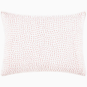 A John Robshaw Organic Hand Stitched Lotus Quilt with a pink and white pillow with dots on an organic cotton voile coverlet.