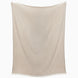The Lavanya Sand Throw by John Robshaw, a beige herringbone blanket with fringed edges, hangs flat against a white background.