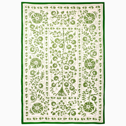 John Robshaw Drawn In Thread Suzani Blanket, a rectangular throw with an off-white background, intricate botanical embroidery, vines, and a solid green border.
