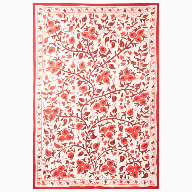 John Robshaw Harvest Poppy Suzani blanket in a rectangular, vintage style with a red-and-white botanical pattern of scrolling pomegranate vines and flowers enclosed by a solid red border.