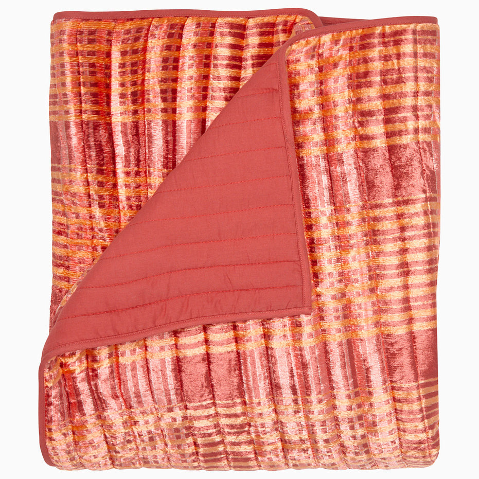 The Jatin Terracotta Throw by John Robshaw features a patterned velvet texture in pink, orange, and gold with a solid pink back, shown on a plain background.