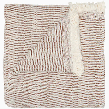 The Lavanya Coffee Throw by John Robshaw features a folded beige and brown herringbone weave with fringed edges, showing both front and back sides.