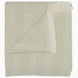 The Lavanya Sage Throw by John Robshaw is a folded, light cotton blanket featuring a subtle herringbone pattern and one fringed edge.