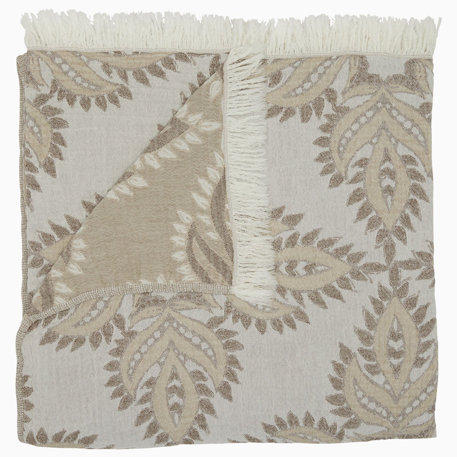 The Dasati Sand Throw by John Robshaw is a beige and white patterned blanket made from stonewashed cotton, featuring fringed edging and partially folded to reveal the woven design on the reverse side.