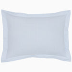 The Cinde Light Indigo Organic Duvet by John Robshaw is a rectangular pillow with a light blue and white patterned cover, featuring a 200 thread count percale with small repeated designs and a flanged edge.