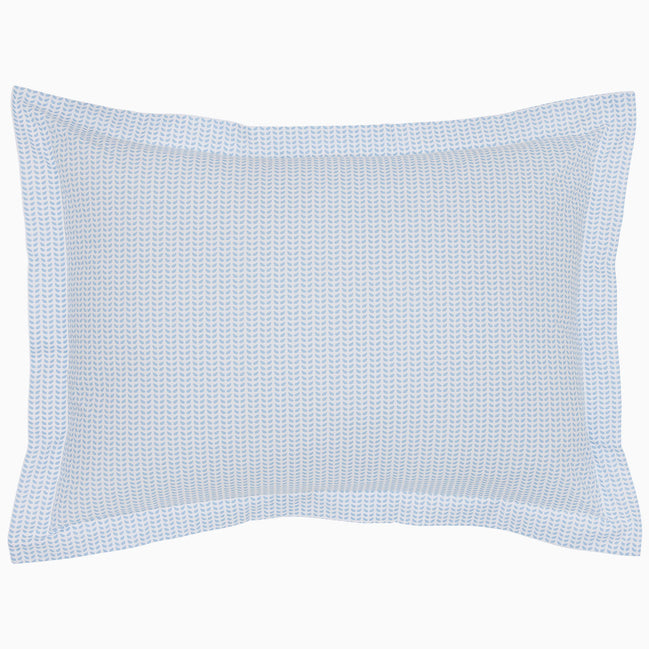 The Cinde Light Indigo Organic Duvet by John Robshaw is a rectangular pillow with a light blue and white patterned cover, featuring a 200 thread count percale with small repeated designs and a flanged edge.
