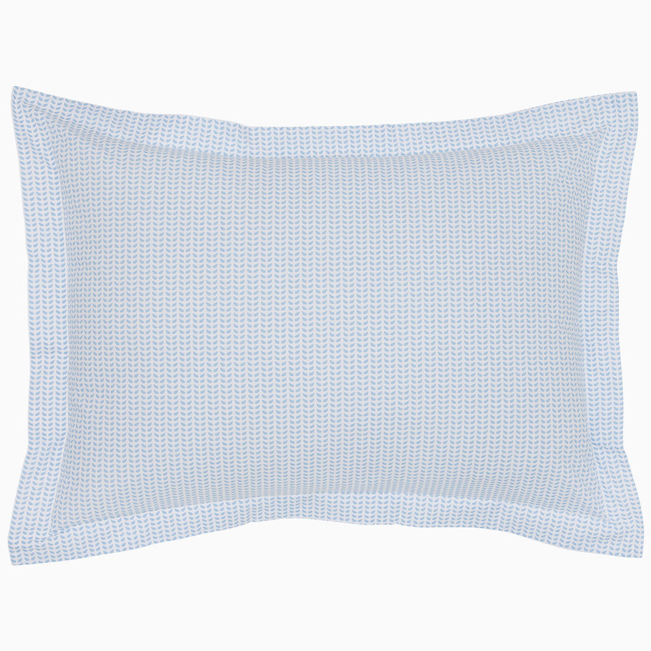 The Cinde Light Indigo Organic Duvet by John Robshaw is a rectangular pillow with a light blue and white patterned cover, featuring a 200 thread count percale with small repeated designs and a flanged edge.