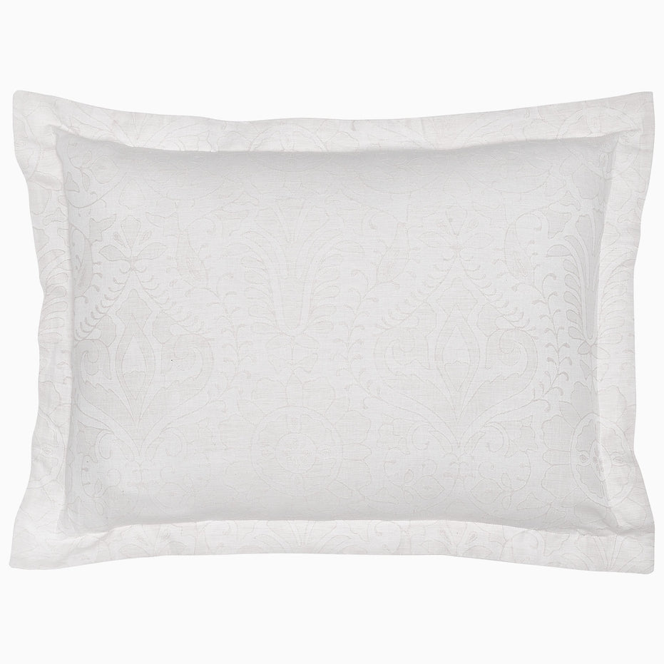 A decorative rectangular white pillow, part of the Amina Ecru Duvet Set by John Robshaw, featuring intricately woven lines and subtle floral patterns, crafted from the finest quality cotton linen.
