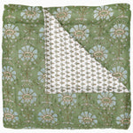 The Jeeva Sage Quilt by John Robshaw, featuring a charming green floral pattern and hand-quilted craftsmanship, showcases a folded corner that reveals a white fabric underside adorned with a delicate smaller floral design, evoking the charm of a spring meadow. - 31272430567470