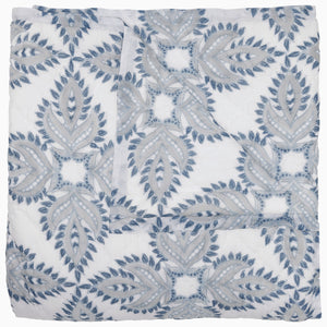 Folded John Robshaw's Dasati Lapis Quilt, featuring a blue and gray geometric leaf pattern, crafted from cotton voile.