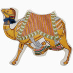 Introducing the Tiny Camel Pillow by John Robshaw, a decorative pillow meticulously designed in the shape of an ornate camel. This exquisite piece features intricate embroidery and vibrant colors, enhanced with patterned details such as a saddle and tassels. Made in India, it showcases traditional craftsmanship with beautiful embroidered and beaded accents. - 31272630583342