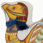 The Tiny Camel Pillow by John Robshaw is adorned with an ornate camel, embroidered and beaded with colorful tassels, featuring intricate details and vibrant colors. Made in India. - 31272641789998