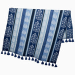 The Malvika Lapis Throw by John Robshaw is a hand-printed textile made of 100% cotton voile, featuring blue and white vertical stripes and tassels along the bottom edge. - 31272448589870