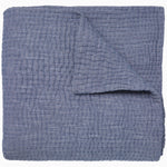 A Vivada Indigo Woven Quilt by John Robshaw folded on top of itself. - 30252475187246