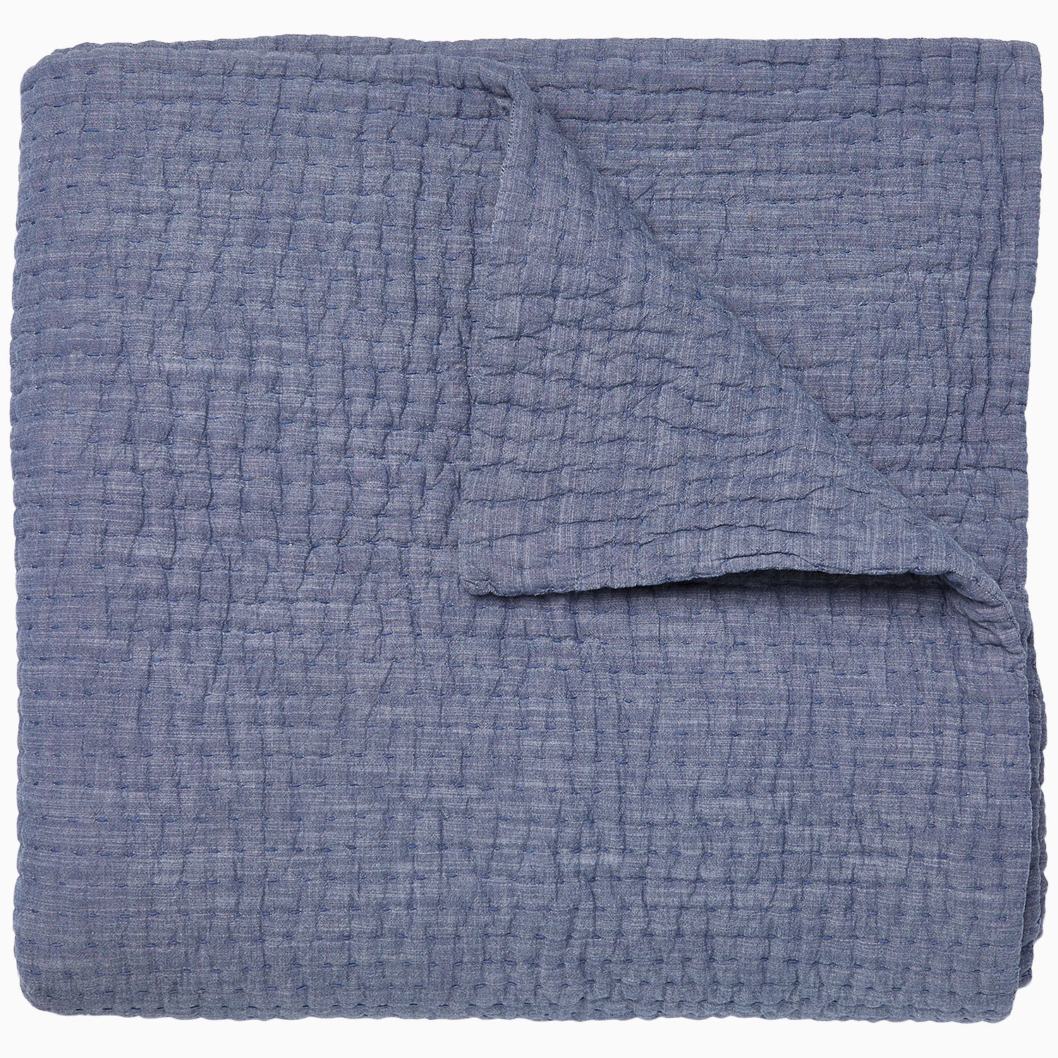 A Vivada Indigo Woven Quilt by John Robshaw folded on top of itself.