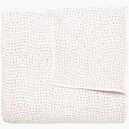 A white and pink Organic Hand Stitched Lotus Quilt with dots, by John Robshaw.