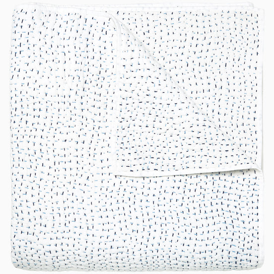 A white Organic Hand Stitched Light Indigo Quilt with blue dots on it, made with hand stitching and cotton voile, by John Robshaw.