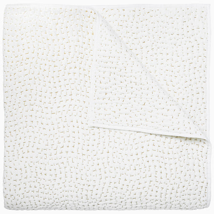 A white cotton voile coverlet featuring John Robshaw's Organic Hand Stitched Sand Quilt with subtle white dot patterns.