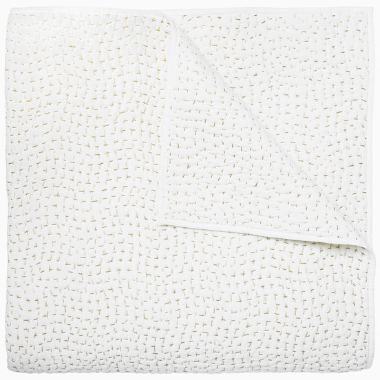 A white cotton voile coverlet featuring John Robshaw's Organic Hand Stitched Sand Quilt with subtle white dot patterns.